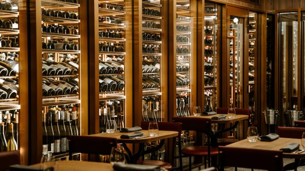 An illuminated glass cellar lines one wall of Circl restaurant.