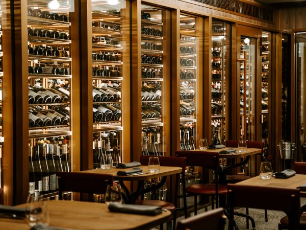 An illuminated glass cellar lines one wall of Circl restaurant.