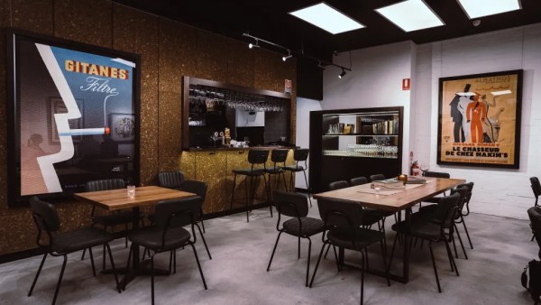 A wide angle shot showing the bar tables and art displayed on the walls of The Art Syndicate.