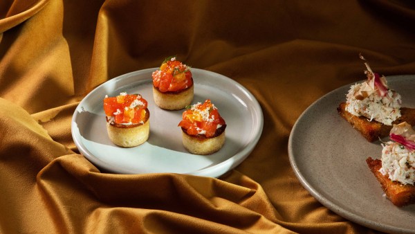 A plate of Mid Air's Petuna Ocean Trout sitting on golden fabric.