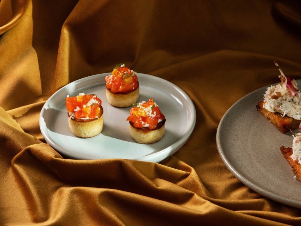 A plate of Mid Air's Petuna Ocean Trout sitting on golden fabric.