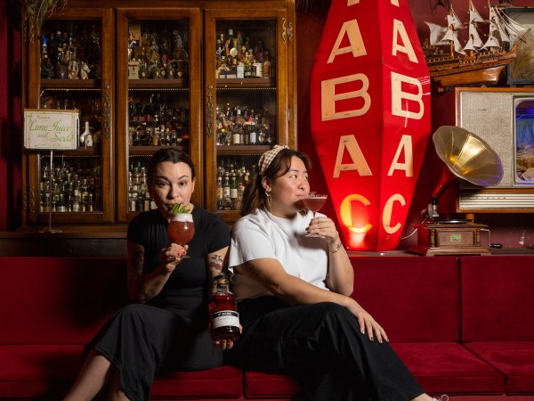 Shirley Yeung and Pippa Canavan of Mix Haus sit on a couch sipping cocktails.