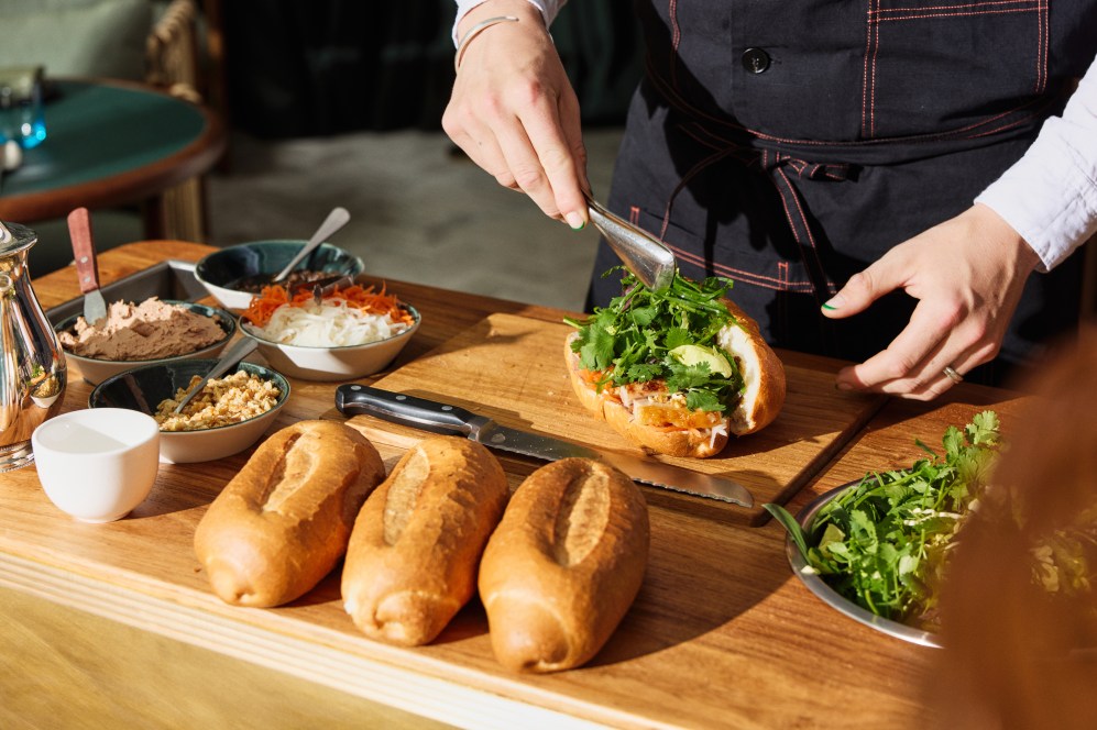 A waiter serves banh mi in Delta Rue.