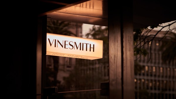 The illuminated restaurant sign reads Vinesmith in black typography.