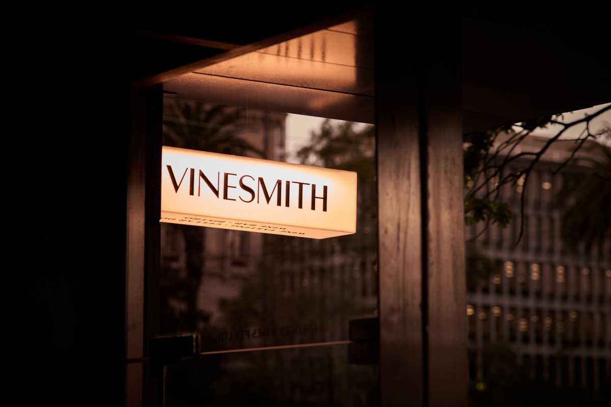 The illuminated restaurant sign reads Vinesmith in black typography.