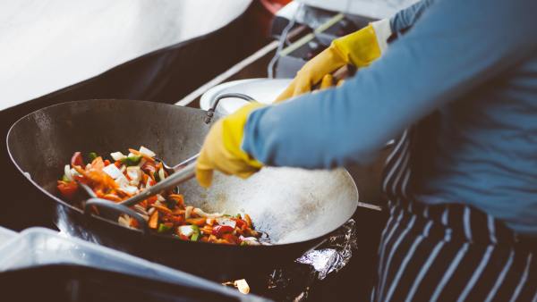 Finding chefs to fill jobs can prove difficult. A cook tosses vegetables in a wok.