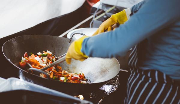 Finding chefs to fill jobs can prove difficult. A cook tosses vegetables in a wok.