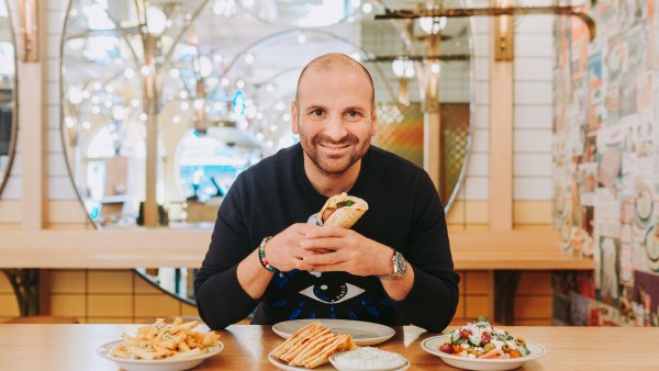 George Calombaris holding a slouvaki in Made Establishment owned jimmy Grants