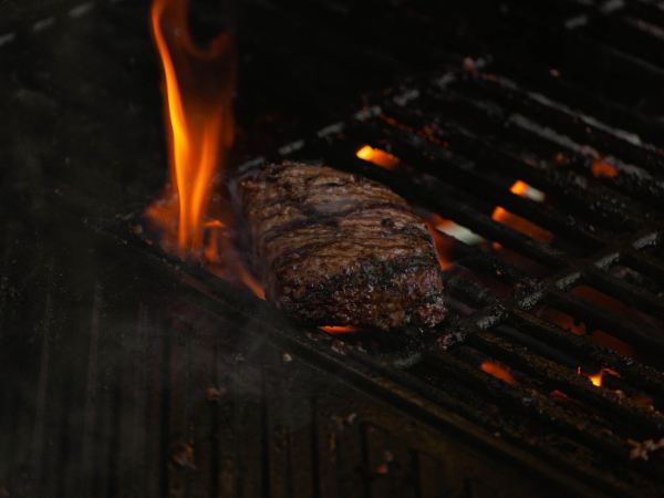 beef on a grill with flames